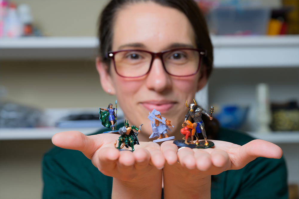 Middle age woman holding out her hands displaying miniature figurines