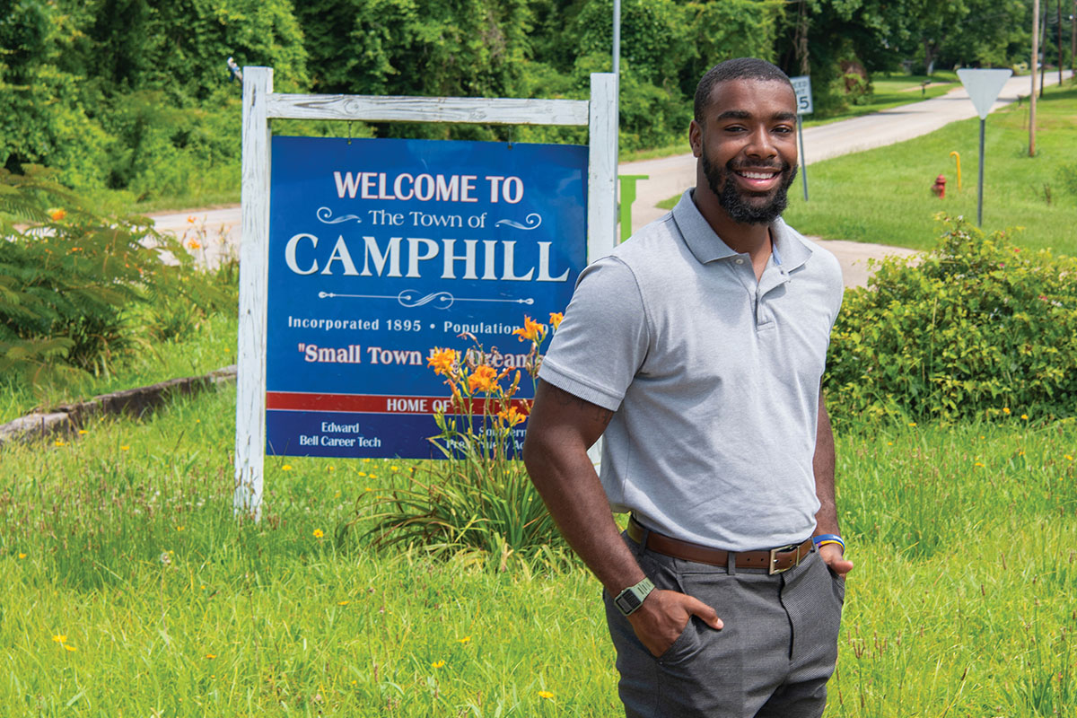 Messiah Williams-Cole standing in front of Camphill Sign