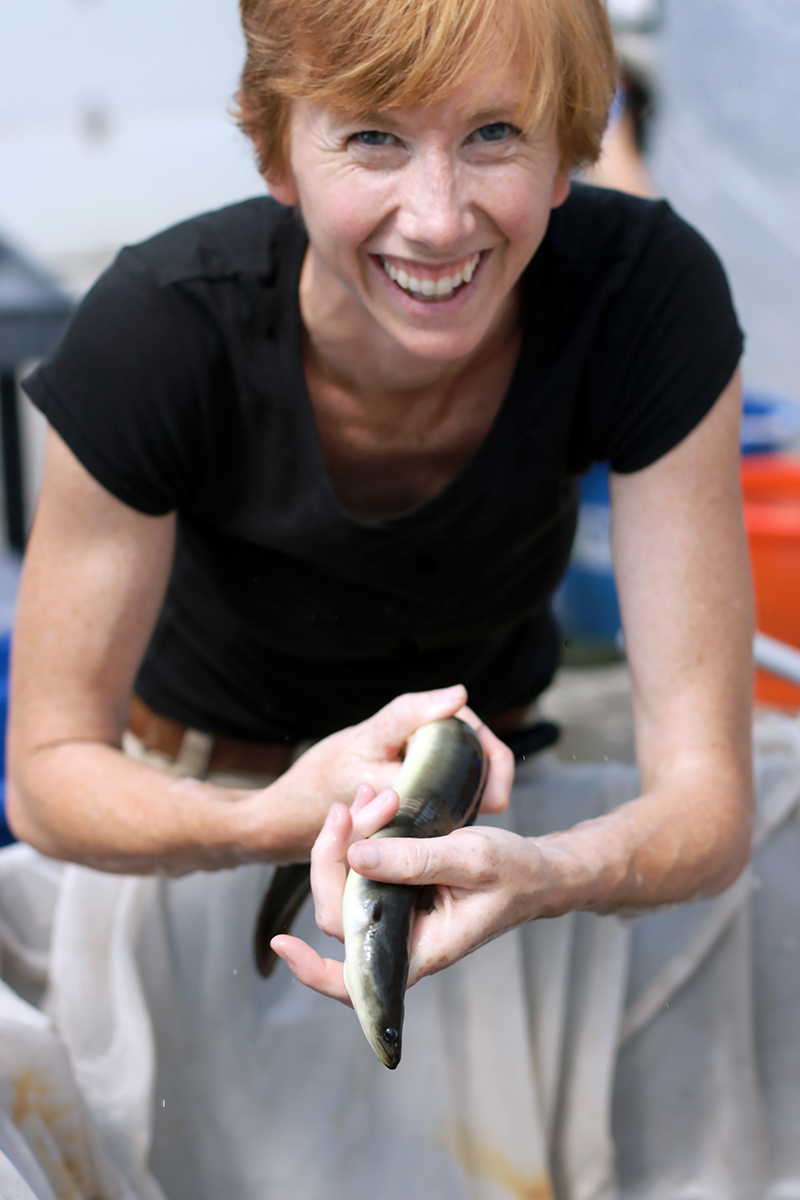 Woman holding an eel in both of her hands