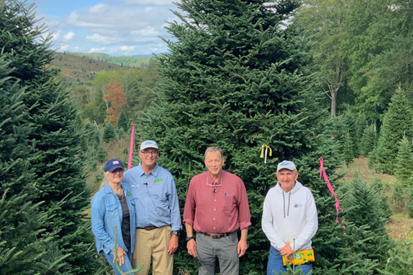 Farmers stand in front of Christmas Tree