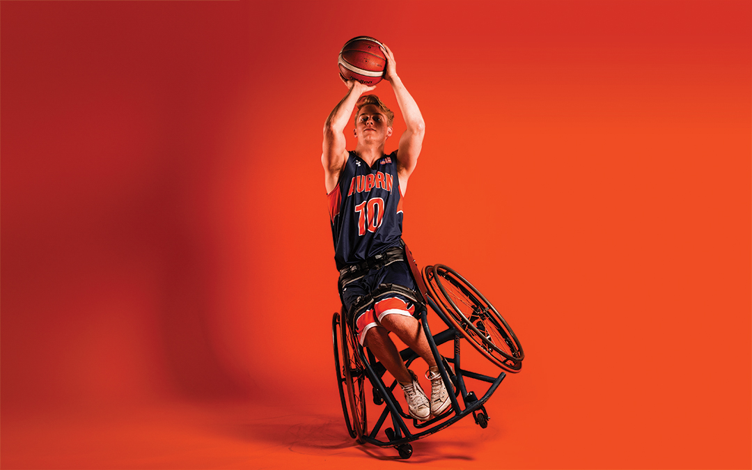 Studio shot of male wheelchair basketball player holding a ball like he is going to shoot